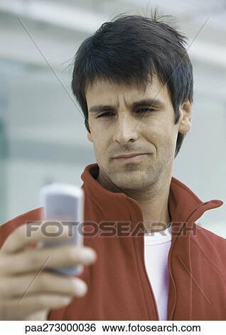 Stock Photograph - Man looking at cell phone. Fotosearch