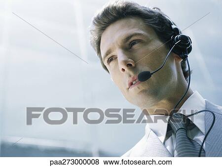 Stock Photo - Man with headset, low angle shot. Fotosearch