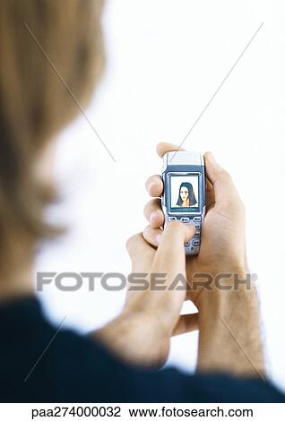 Man holding cellphone displaying woman's picture View Large Photo Image Stock Image - Man holding cellphone displaying woman's picture. Fotosearch