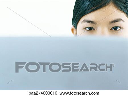 Woman looking over edge of screen, looking at camera View Large Photo Image Stock Photograph - Woman looking over edge of screen, looking at camera. Fotosearch