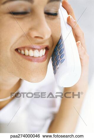 Woman talking on cordless phone with eyes closed, smiling View Large Photo Image Stock Photograph - Woman talking on cordless phone with eyes closed, smiling. Fotosearch