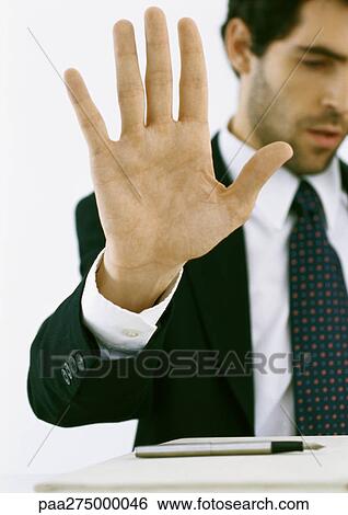 Businessman holding up hand and looking down View Large Photo Image Stock Photograph - Businessman holding up hand and looking down. Fotosearch