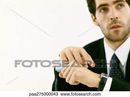 Businessman pointing to watch and looking up View Large Photo Image Stock Image - Businessman pointing to watch and looking up. Fotosearch