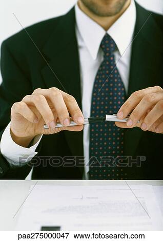 Businessman putting cap on pen, partial view View Large Photo Image Stock Photo - Businessman putting cap on pen, partial view. Fotosearch