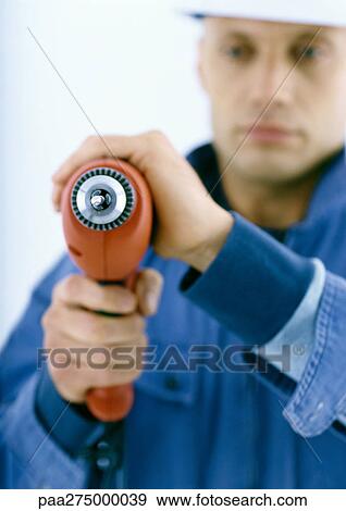 Man holding drill View Large Photo Image Stock Photo - Man holding drill. Fotosearch