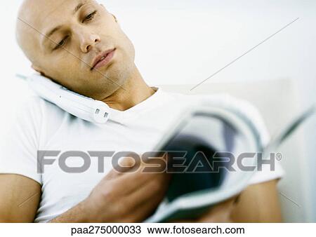 Man talking on phone and looking through magazine View Large Photo Image Stock Image - Man talking on phone and looking through magazine. Fotosearch