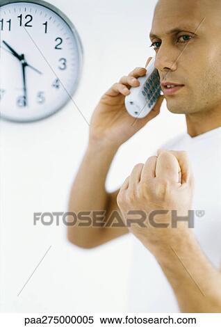 Stock Photography - Man talking on phone, making fist. Fotosearch