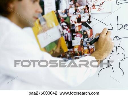 Man writing on board with images taped to it View Large Photo Image Stock Image - Man writing on board with images taped to it. Fotosearch