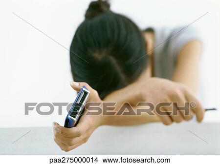 Woman holding electronic organizer, resting head on arms View Large Photo Image Picture - Woman holding electronic organizer, resting head on arms. Fotosearch