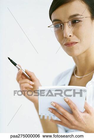 Woman holding notepad and pen View Large Photo Image Stock Photograph - Woman holding notepad and pen. Fotosearch