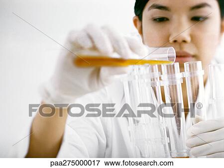 Woman transferring contents of test tube View Large Photo Image Stock Photo - Woman transferring contents of test tube. Fotosearch