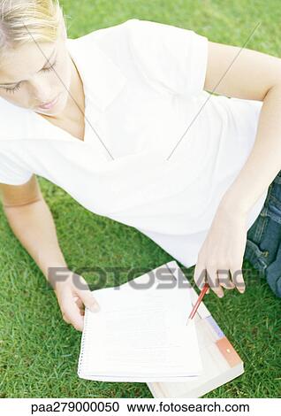 Female student reclining on grass, studying View Large Photo Image Stock Image - Female student reclining on grass, studying. Fotosearch