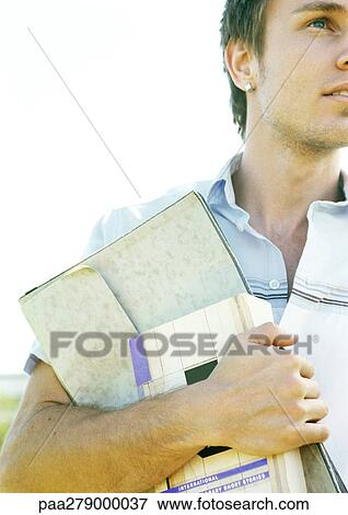 Male student carrying book and folder, partial view, close-up View Large Photo Image Stock Photo - Male student carrying book and folder, partial view, close-up. Fotosearch