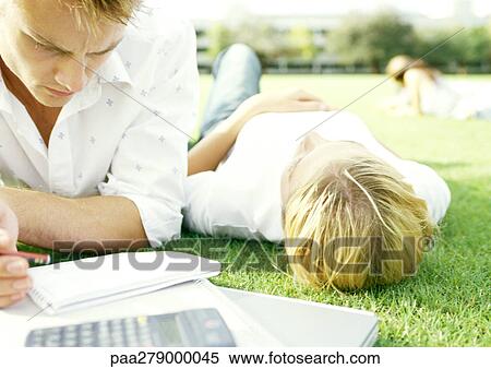 Students lying on grass, young man studying, young woman lying on back View Large Photo Image Stock Photography - Students lying on grass, young man studying, young woman lying on back. Fotosearch