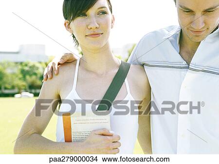 Young couple, man's arm around woman's shoulder View Large Photo Image Picture - Young couple, man's arm around woman's shoulder. Fotosearch