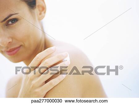 Woman applying sunscreen to shoulder, partial view View Large Photo Image Stock Image - Woman applying sunscreen to shoulder, partial view. Fotosearch