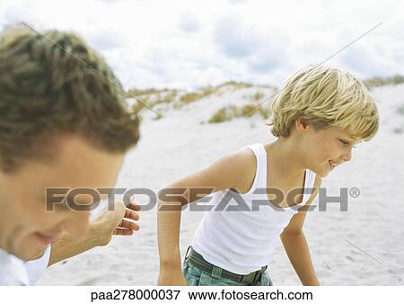 Stock Photo - Boy and father runnng on beach. Fotosearch