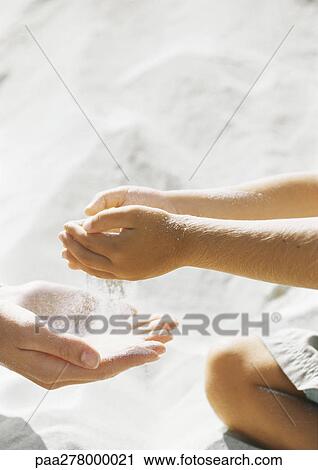 Child letting sand run through cupped hands into mother's hands View Large Photo Image Stock Image - Child letting sand run through cupped hands into mother's hands. Fotosearch