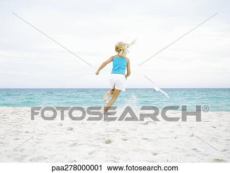 Girl running after seagull on beach View Large Photo Image Stock Image - Girl running after seagull on beach. Fotosearch