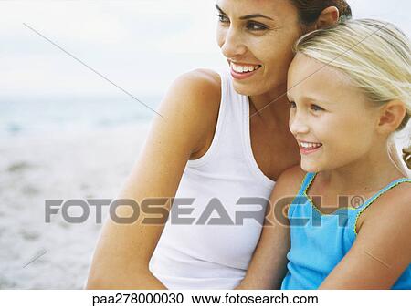 Girl sitting with mother on beach View Large Photo Image Stock Image - Girl sitting with mother on beach. Fotosearch