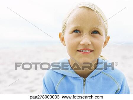 Stock Image - Little girl on beach, portrait. Fotosearch