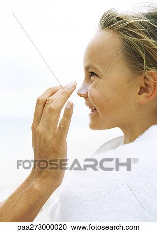 Little girl wrapped in towel having sunscreen rubbed into nose by mother View Large Photo Image Stock Image - Little girl wrapped in towel having sunscreen rubbed into nose by mother. Fotosearch