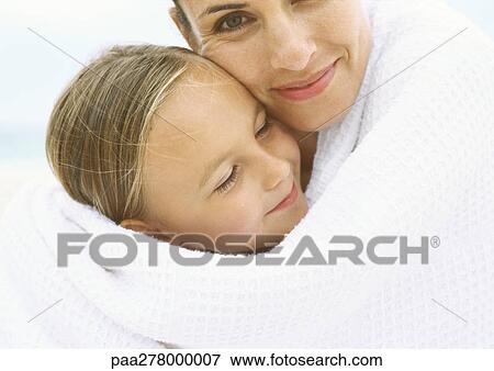 Stock Photo - Mother and daughter wrapped in towel, portrait. Fotosearch
