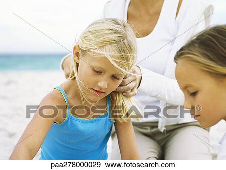 Stock Photo - Two girls and mother on beach. Fotosearch