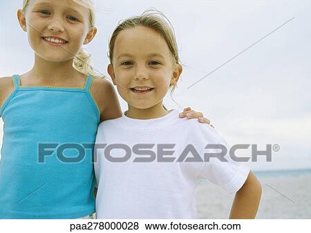 Two little girls standing side by side on beach View Large Photo Image Stock Photo - Two little girls standing side by side on beach. Fotosearch