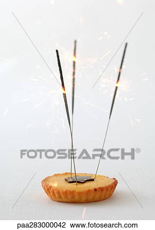 Stock Image - Tartlet decorated with sparklers. Fotosearch