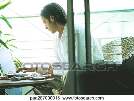 Man using laptop on terrace View Large Photo Image Stock Photography - Man using laptop on terrace. Fotosearch
