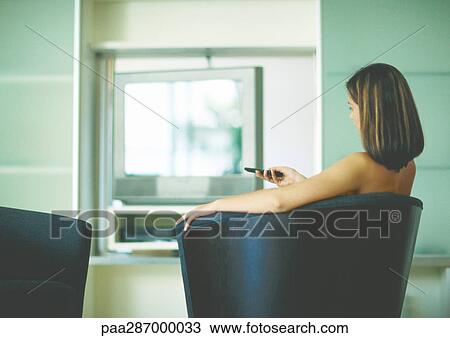 Woman sitting in arm chair, channel surfing View Large Photo Image Stock Image - Woman sitting in arm chair, channel surfing. Fotosearch