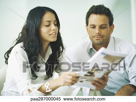 Young adults examining catalog View Large Photo Image Stock Photography - Young adults examining catalog. Fotosearch
