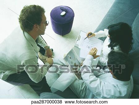 Young adults examining designs, high angle view View Large Photo Image Stock Photo - Young adults examining designs, high angle view. Fotosearch