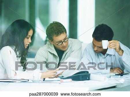 Young adults examining documents View Large Photo Image Stock Photo - Young adults examining documents. Fotosearch