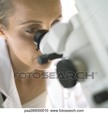 Doctor looking through microscope View Large Photo Image Stock Image - Doctor looking through microscope. Fotosearch