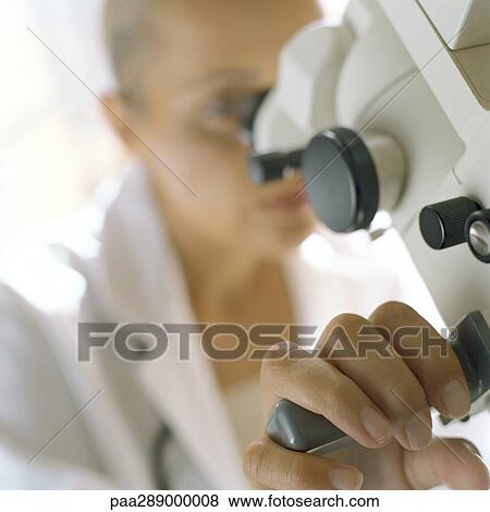 Stock Photo - Doctor looking through microscope. Fotosearch