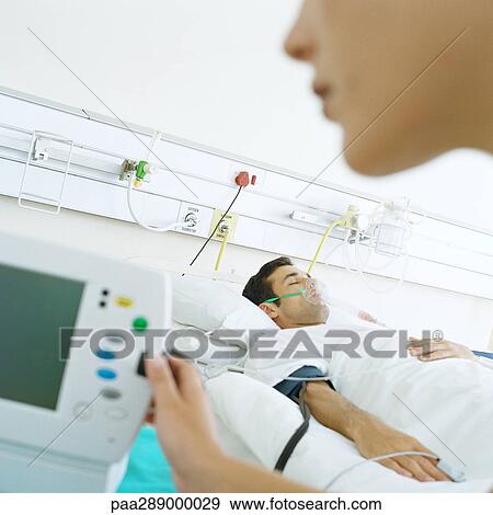 Nurse checking patient's monitor View Large Photo Image Stock Photo - Nurse checking patient's monitor. Fotosearch