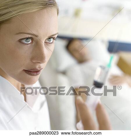 Nurse holding up syringe in front of patient View Large Photo Image Stock Image - Nurse holding up syringe in front of patient. Fotosearch