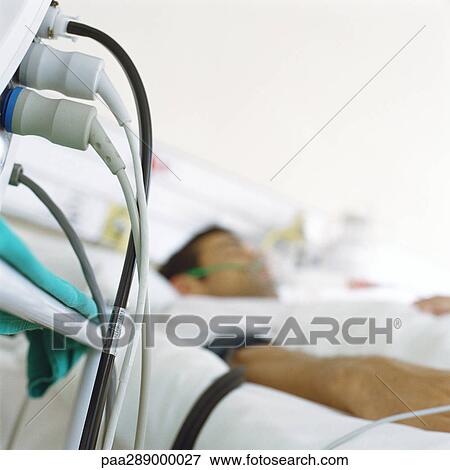 Patient in hospital bed and wires from monitor View Large Photo Image Stock Photo - Patient in hospital bed and wires from monitor. Fotosearch