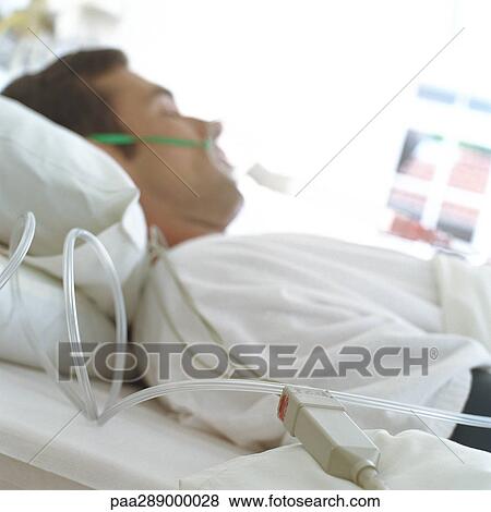 Patient in hospital bed wearing mask View Large Photo Image Stock Photo - Patient in hospital bed wearing mask. Fotosearch
