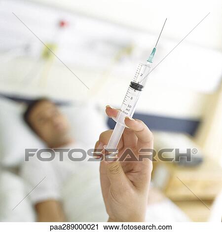 Syringe being held up in front of patient View Large Photo Image Stock Image - Syringe being held up in front of patient. Fotosearch