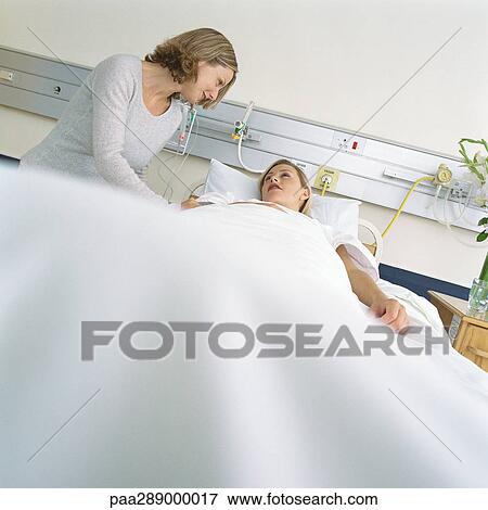 Visitor talking to patient in hospital bed View Large Photo Image Stock Photo - Visitor talking to patient in hospital bed. Fotosearch