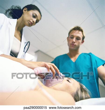 Stock Photography - Doctor adjusting patient's oxygen mask. Fotosearch