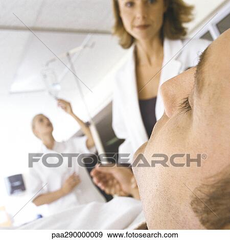 Stock Photo - Doctor taking patient's pulse in emergency room. Fotosearch