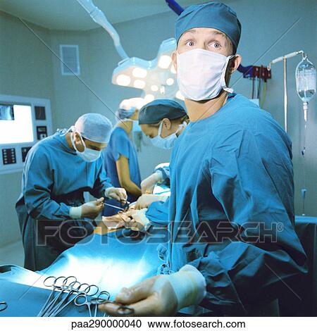 Doctors performing operation View Large Photo Image Stock Image - Doctors performing operation. Fotosearch