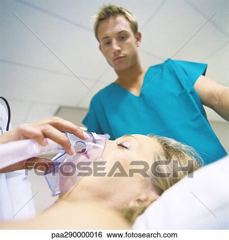Intern looking down at patient with oxygen mask View Large Photo Image Stock Photograph - Intern looking down at patient with oxygen mask. Fotosearch
