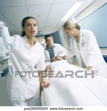 Medical team pushing patient on gurney View Large Photo Image Picture - Medical team pushing patient on gurney. Fotosearch