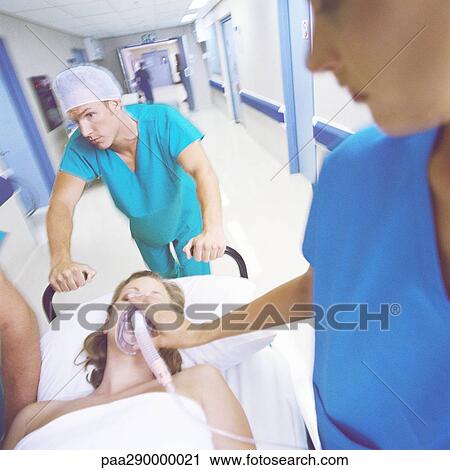 Stock Image - Medical team pushing patient on gurney . Fotosearch