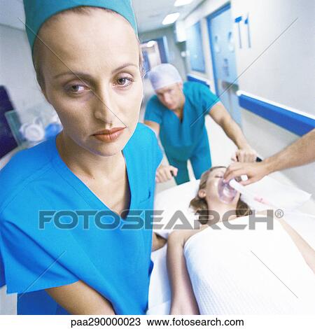 Stock Image - Medical team pushing patient on gurney . Fotosearch